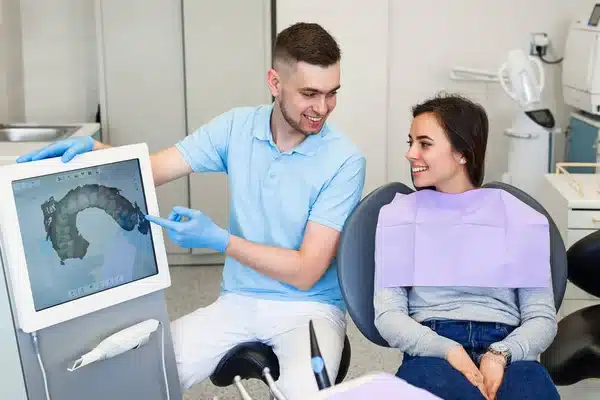 Profissional mostrando escaneamento facial digital para paciente durante consulta de Harmonização Facial para Peles Sensíveis.