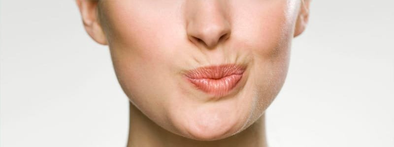Mulher com expressão labial evidenciando as Linhas ao Redor da Boca, foco em estética perioral.